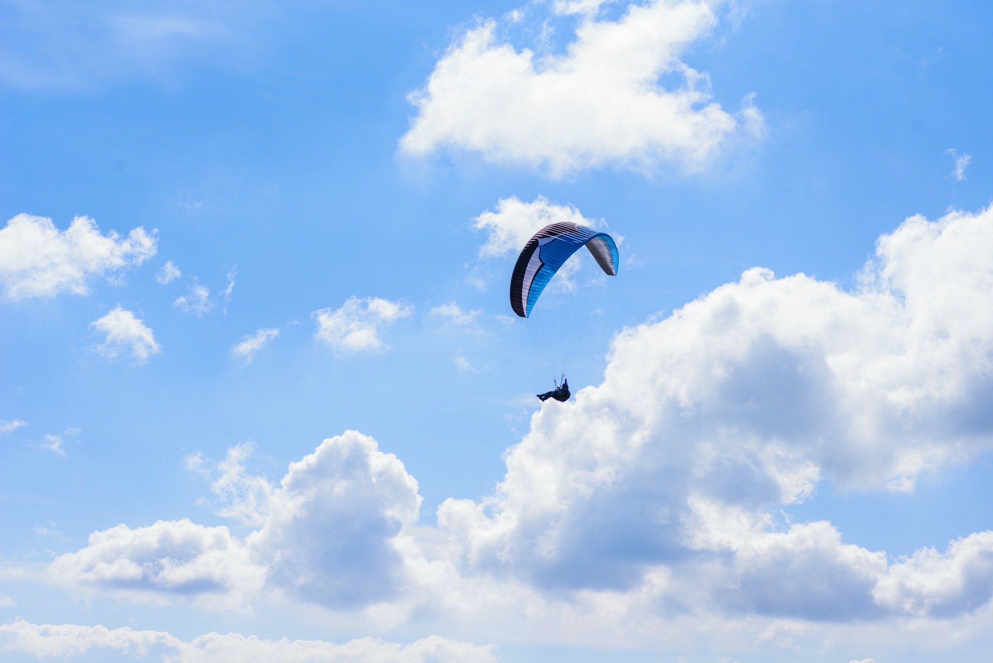 man on a parachute flying in the clear sky